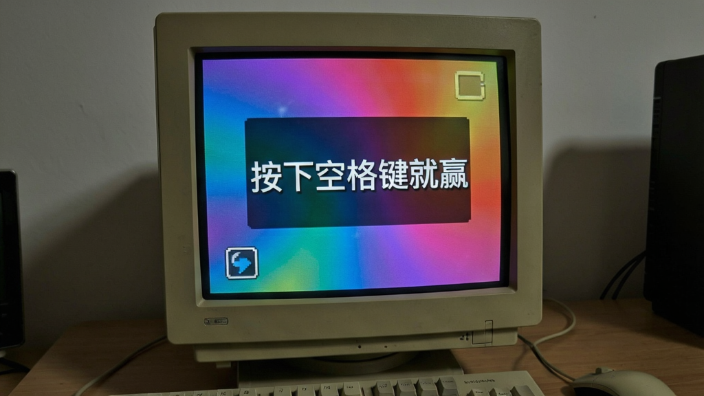 一个电脑屏幕显示“按下空格键就赢”的游戏界面,背景为彩色渐变