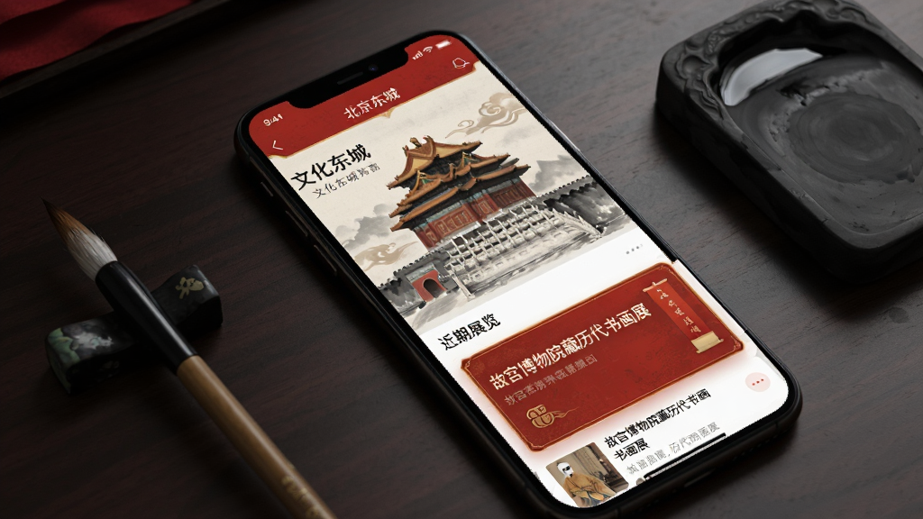 展示“北京东城”APP的“文化东城”板块,屏幕中展示一幅故宫角楼的水墨画背景,下方有“近期展览”列表,其中“故宫博物院藏历代书画展”的卡片被放大,界面设计充满中国风元素,红色与金色搭配,手机斜放在深色桌面上,旁边有毛笔和砚台,画质典雅精致,干净无多余元素