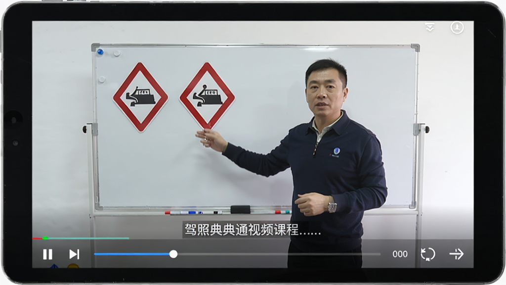 主体为驾照典典通视频课程播放页面,屏幕中教练站在白板前讲解交通标志,布局上部视频下部字幕,排版舒适,风格写实,细节包含播放进度条和倍速按钮,画质清晰,干净无多余元素。