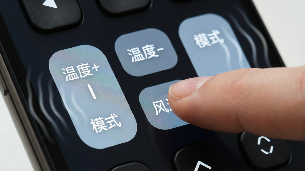 一张特写万能家电智慧遥控大尺寸按键的图片,主体为手机屏幕上的空调控制按键区域,按键清晰标注“温度+”、“温度-”、“模式”、“风速”等字样,手指正在点击其中一个按键,屏幕边缘有微弱的震动波纹效果。布局饱满,风格写实,细节丰富,画质干净,无多余元素。