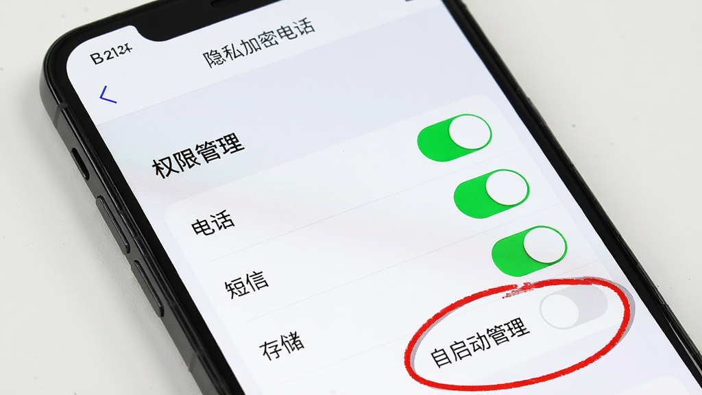 主体:一部手机展示“隐私加密电话”的设置界面,突出权限管理选项。布局:屏幕中央显示“权限管理”菜单,下方罗列“电话”、“短信”、“存储”等权限开关。排版:界面简洁,开关按钮为绿色,当前状态为全部开启。风格:实用、清晰。细节:用红圈标出“自启动管理”选项。画质:高清,干净,无多余元素。