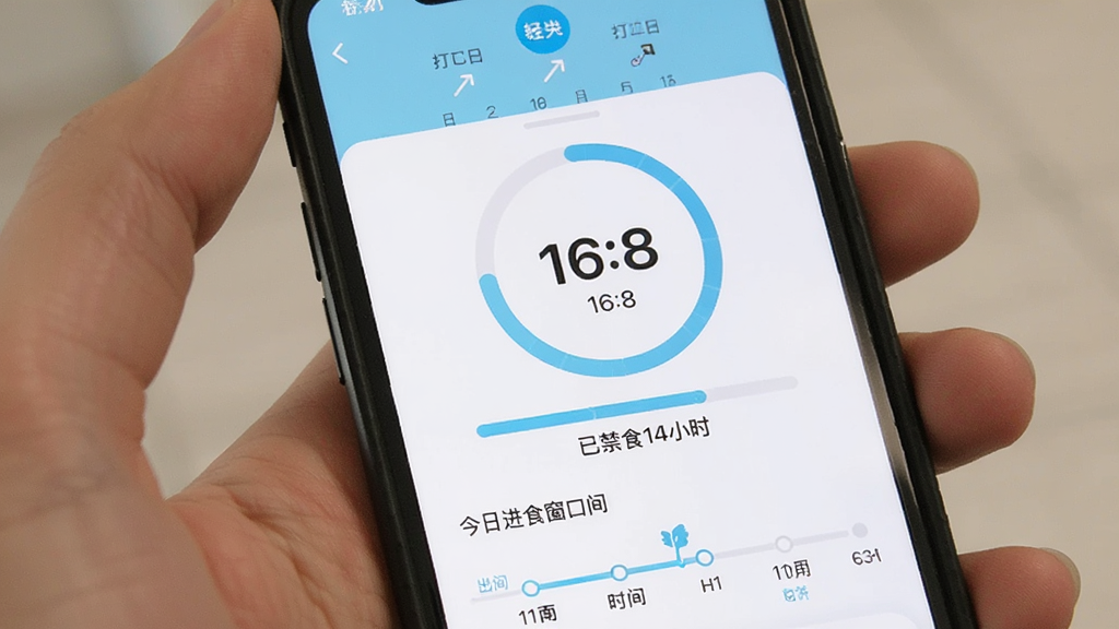 轻食计轻断食追踪界面,手机显示16:8断食倒计时圆环,进度条显示已禁食14小时,下方有今日进食窗口时间轴,顶部有日历打卡标记,界面采用浅蓝色与白色配色,简洁直观,画质清晰,无多余元素